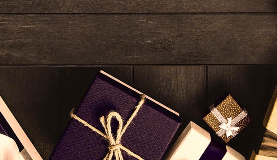 photo of gold, white, and purple presents on a wood table