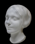 Photo of the mask of La Belle Italienne in white plaster on a black background
