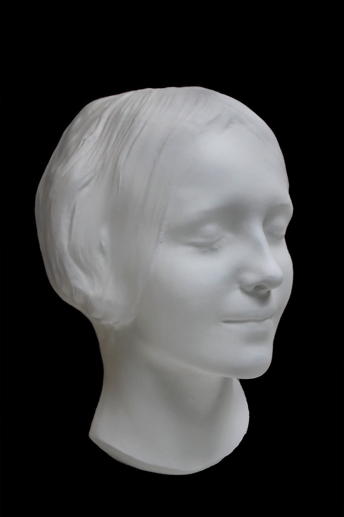 Photo of the mask of La Belle Italienne in white plaster on a black background