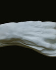 Photo of a white plaster cast of an elderly hand on a black background