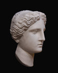 image of plaster cast sculpture mask of female, namely Athena, on a black background