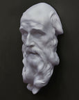 photo of plaster cast of the male face of Saint Andrew with long beard on gray background
