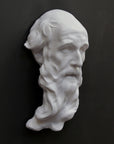 photo of plaster cast of the male face of Saint Andrew with long beard on gray background