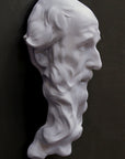 photo of plaster cast of the male face of Saint Andrew with long beard on gray background