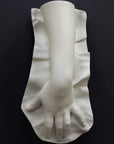 Plaster cast of a female hand on a black background