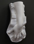 Plaster cast of a female hand on a black background