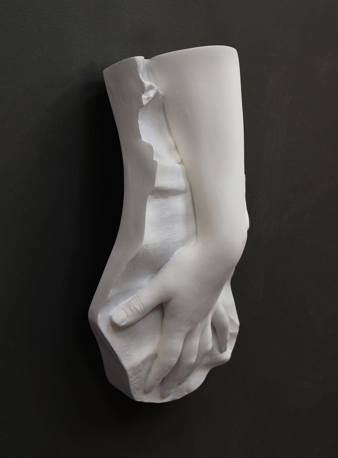 Plaster cast of a female hand on a gray background
