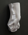 Plaster cast of a female hand on a black background