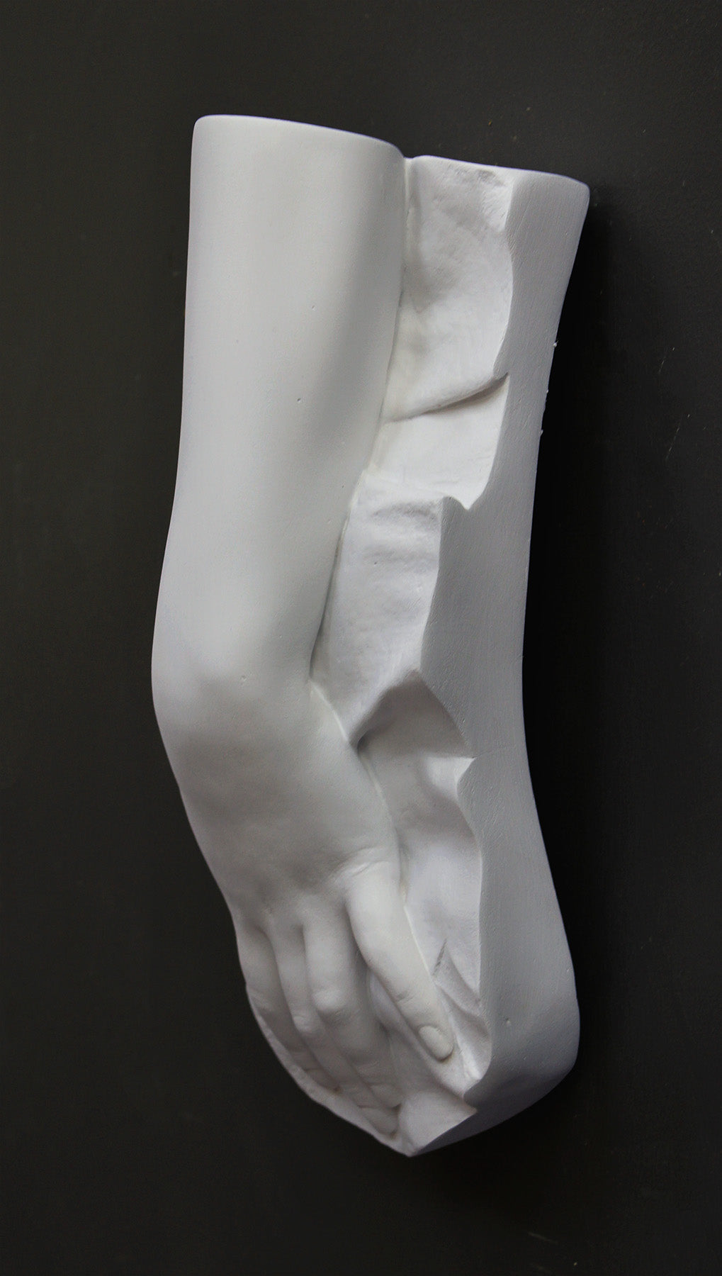 Plaster cast of a female hand on a gray background