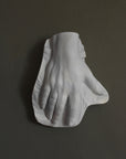 Photo of a plaster hand on a gray background