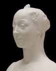 photo of white plaster cast of female bust with up-do and dress against black background