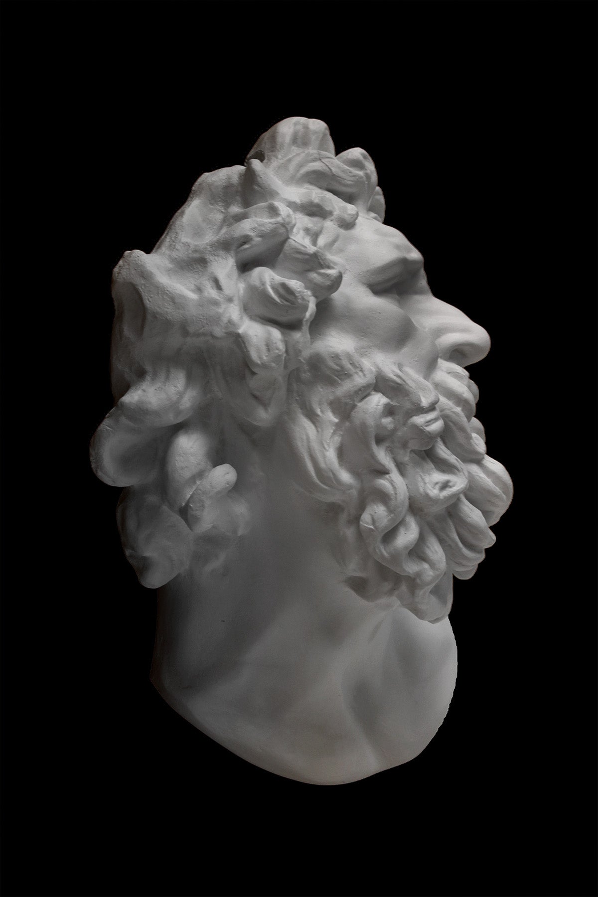 Photo of a plaster cast of the Laocoon mask on a black background