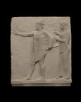 photo of plaster cast sculpture relief of two figures walking to the left, the male reaching out his right hand and the female behind him