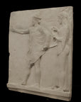 photo of plaster cast sculpture relief of two figures walking to the left, the male reaching out his right hand and the female behind him