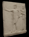 photo of plaster cast sculpture relief of two figures walking to the left, the male reaching out his right hand and the female behind him