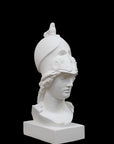 photo of plaster cast sculpture bust of female head, namely the goddess Athena, with a helmet on a black background