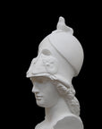 photo of plaster cast sculpture bust of female head, namely the goddess Athena, with a helmet on a black background