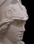 photo of plaster cast sculpture bust of female head, namely the goddess Athena, with a helmet on a black background