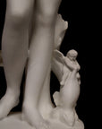 detail photo of plaster cast sculpture of Venus standing nude with two putti riding a dolphin at her feet on black background