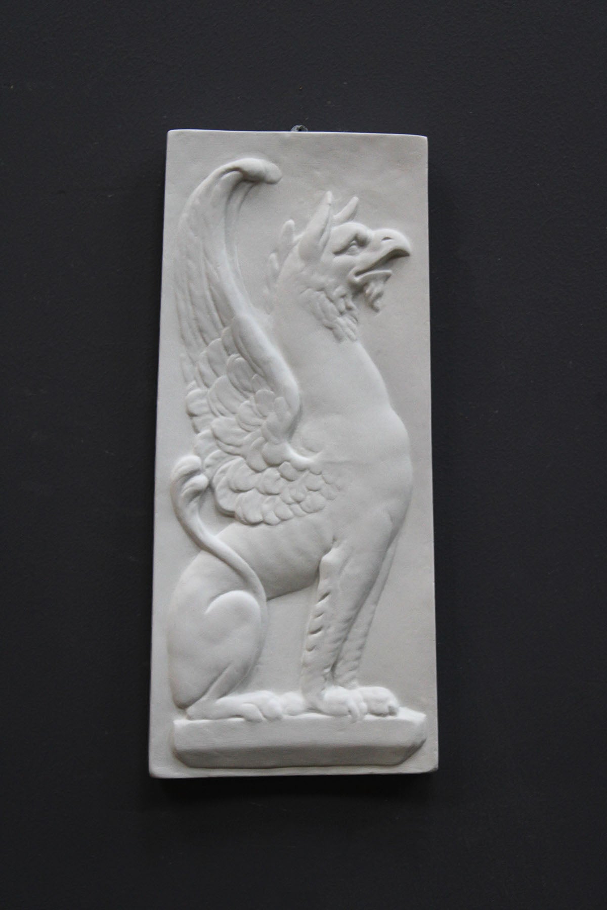 image of a plaster statue of a bust of griffin on a gray background