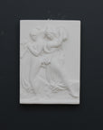 Photo with black background of plaster cast sculpture relief of females playing instruments