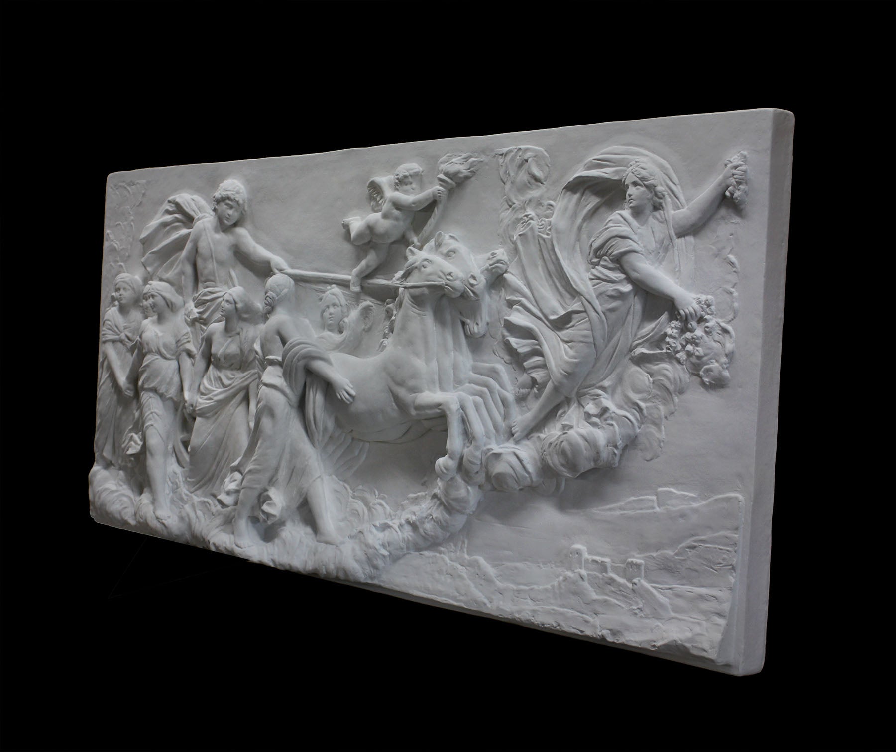 photo of a plaster cast sculpture relief of a woman, namely the goddess Aurora, flying and leading a chariot with a man pulled by horses towards the right while a cherub and other women fill the scene, on a black background