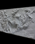 photo of a plaster cast sculpture relief of a woman, namely the goddess Aurora, flying and leading a chariot with a man pulled by horses towards the right while a cherub and other women fill the scene, on a black background