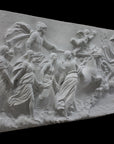 photo of a plaster cast sculpture relief of a woman, namely the goddess Aurora, flying and leading a chariot with a man pulled by horses towards the right while a cherub and other women fill the scene, on a black background