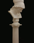 photo of plaster cast sculpture bust of female head, namely the goddess Minerva, with a helmet and looking down and placed on a pedestal with black background