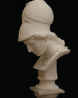 photo of plaster cast sculpture bust of female head, namely the goddess Minerva, with a helmet and looking down and placed on a pedestal with black background