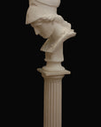 photo of plaster cast sculpture bust of female head, namely the goddess Minerva, with a helmet and looking down and placed on a pedestal with black background