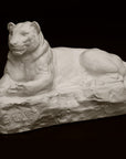 Photo of a sculpture of a Panther reclining on a black background