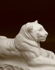 Photo of a sculpture of a Panther reclining on a black background