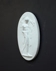 Image of a small plaster plaque of Hercules carrying a boar on a black background