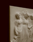 Photo with black background of plaster cast sculpture relief of females dancing