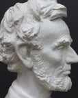 detail image of a plaster sculpture bust of man, namely Abraham Lincoln, on a gray background