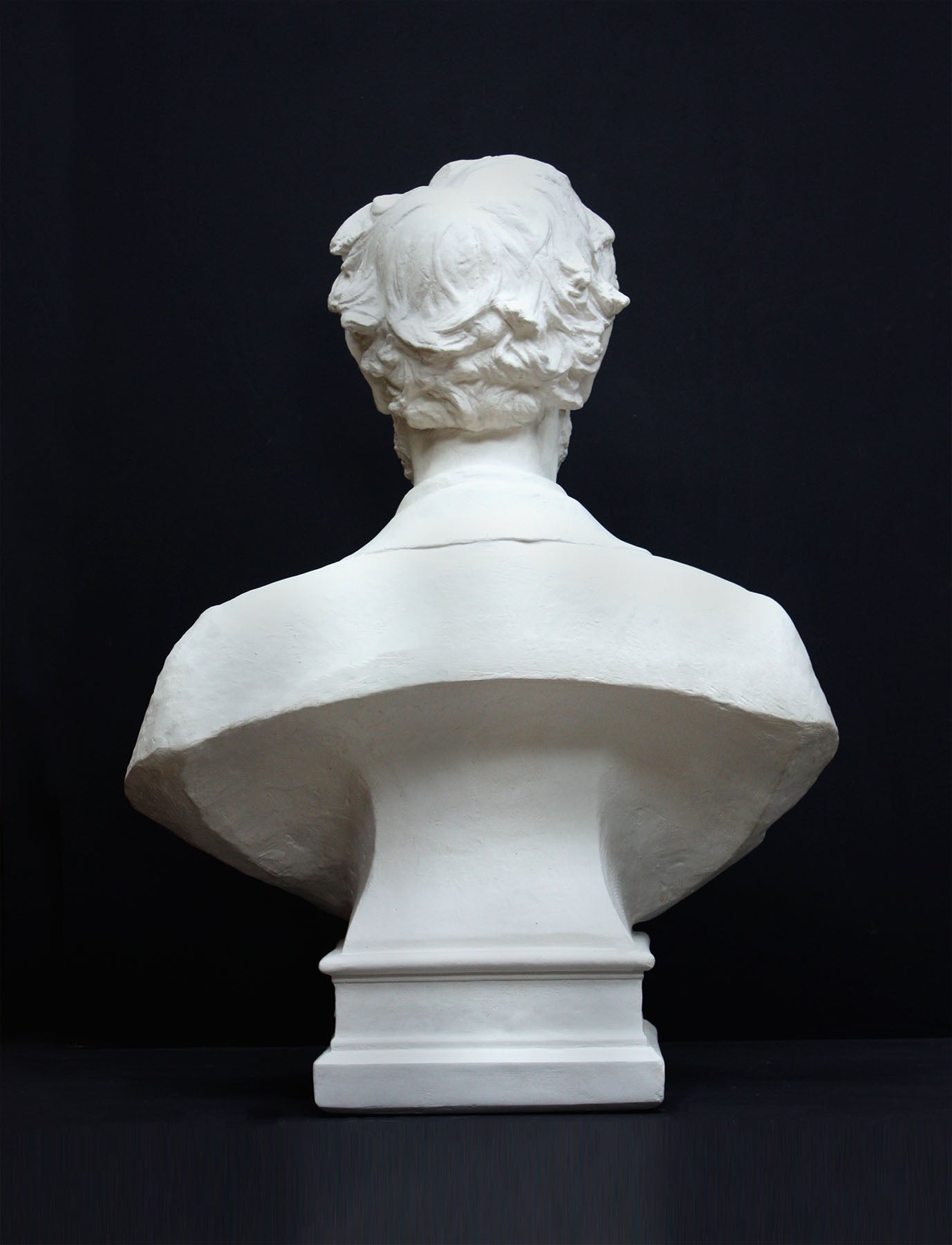 image of a plaster sculpture bust of man, namely Abraham Lincoln, on a gray background