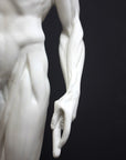 photo of plaster cast sculpture of flayed male figure study with right arm outstretched and left arm down on a gray background