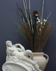 photo of a sculpture of a reclining nude female on a grey background