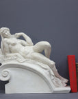 photo of a sculpture of a reclining nude female on a grey background