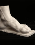 photo of a sculpture of a foot on a black background