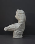 image of a plaster sculpture of nude male torso on a gray background