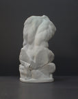 image of a plaster sculpture of nude male torso on a gray background