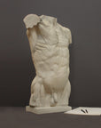 photo of plaster cast of sculpted flayed male torso next to a pen and sketchpad on a gray background
