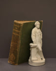 image of a plaster statue of a bust of wagner next to books on a gray background