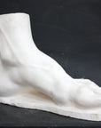 photo of a sculpture of a foot on a black background