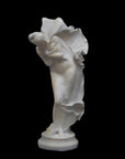 image of a plaster statue of a dancer with flowing drapery on a black background