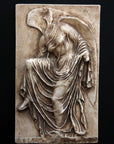 photo of cast of sculpture relief of robed figure, head now missing, reaching for her sandal in a brown patina on a dark gray background