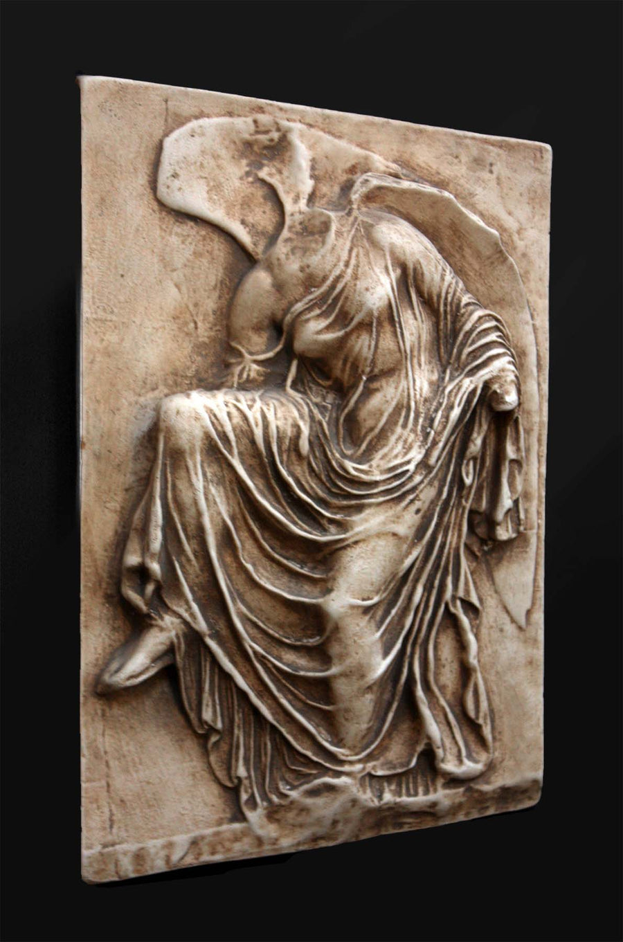 photo of cast of sculpture relief of robed figure, head now missing, reaching for her sandal in a brown patina on a dark gray background