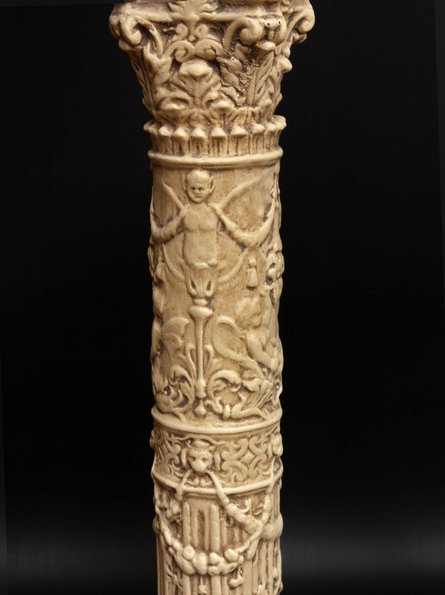photo of plaster cast of ornamental tan-colored candlestick with black background